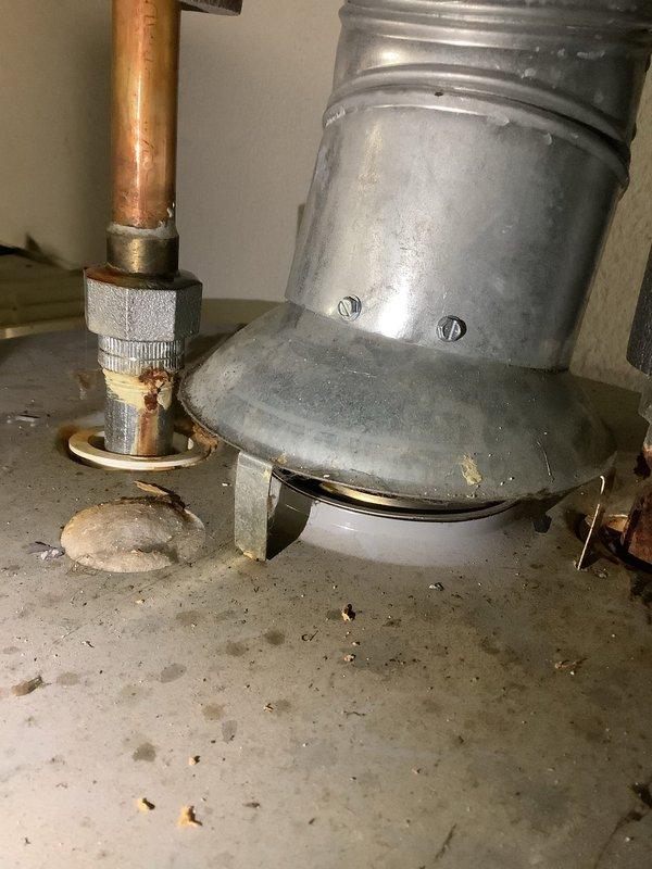 Responded to no hot water complaint on tanked water heater system. Upon inspection, discovered the flue vent pipe had become disconnected from the water heater draft hood assembly. The galvanized vent pipe separation created an unsafe venting condition and prevented proper draft, causing the unit's safety controls to shut down burner operation. Reconnected the flue vent pipe to the draft hood, ensuring proper alignment and secure fit. Verified all venting components were properly seated and sealed. Tested water heater operation after repair, confirmed burner ignition, proper draft through the flue system, and restoration of hot water production. Unit returned to normal operating condition with safe venting restored.