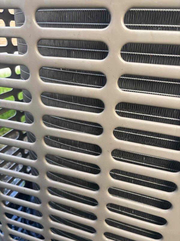 Completed annual preventive maintenance on rooftop cooling unit. Inspected condenser coils and exterior grille assembly, noting minor dust accumulation on protective louvers and heat exchanger fins. Unit operating within normal parameters with all components functioning properly at time of service.