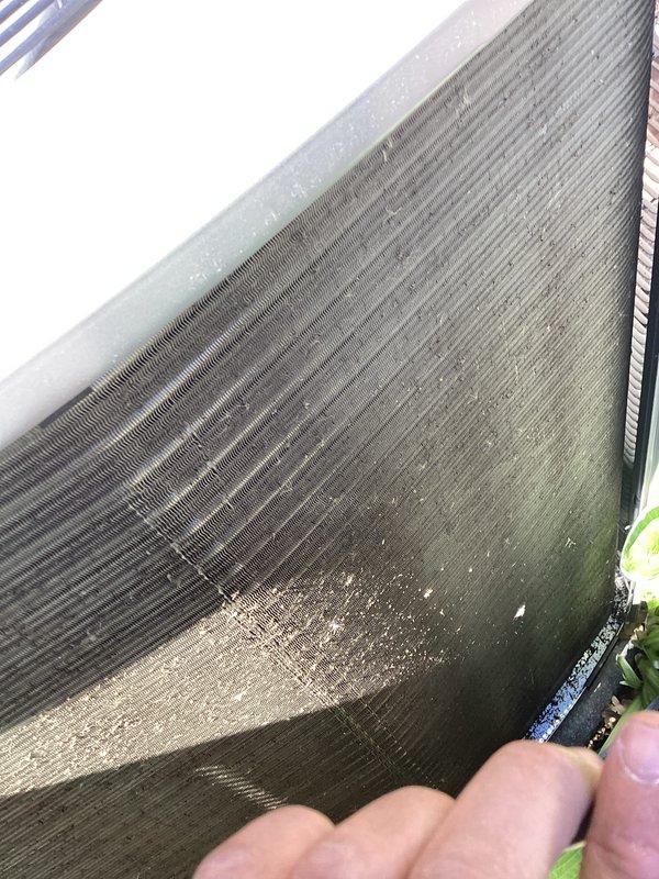 Completed annual cooling maintenance on rooftop zone unit. Inspected condenser coil and found moderate dirt accumulation with concentrated soiling in center and lower sections. Noted significant corrosion damage on portion of coil fins with visible oxidation and surface deterioration requiring monitoring. Documented equipment condition with photos showing debris buildup at base and environmental exposure affecting unit performance. Recommended future coil cleaning to restore heat transfer efficiency.