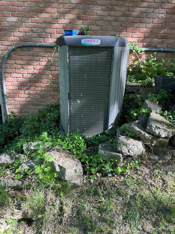 Completed scheduled air conditioning maintenance on residential Lennox condenser unit. Inspected system components, replaced air filter, and documented equipment condition with photos showing unit properly positioned against exterior brick wall with adequate clearance for airflow and service access.