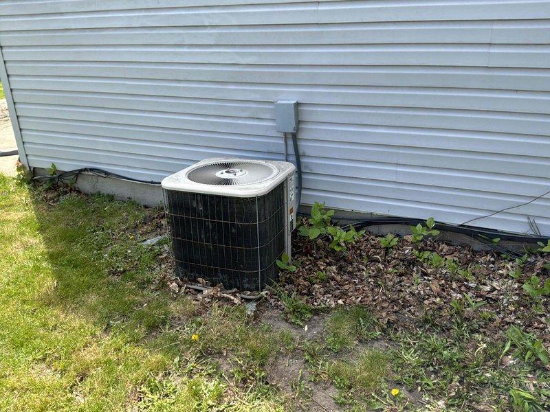 Conducted on-site evaluation of non-operational residential air conditioning system that had reached end of serviceable life at 20+ years old. Assessed existing outdoor condenser unit positioned on concrete pad against exterior wall, documented current system configuration including electrical disconnect and placement conditions. Provided comprehensive replacement estimate for new AC system to restore cooling capacity to residence.