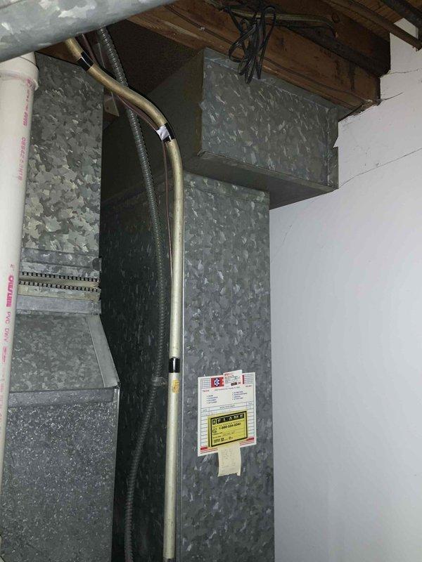 Provided comprehensive estimate for complete HVAC system replacement including furnace, air conditioning unit, and hot water heater, all located in basement mechanical space. Existing equipment is over 17 years old but currently operational, with visible aging infrastructure including deteriorated flooring, older ductwork with galvanized finish, and existing refrigerant lines requiring replacement to accommodate modern efficiency standards.