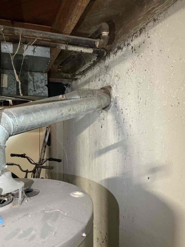 Conducted comprehensive estimate appointment for full HVAC system replacement at residential property. Assessed existing 28-30 year old furnace and air conditioning equipment located in basement utility area, documenting current system configuration including ductwork, venting through masonry chimney, and existing mechanical infrastructure. Photographed installation areas and exterior venting components to provide accurate system replacement proposal, noting both units have reached end of expected service life though currently operational without immediate safety concerns.