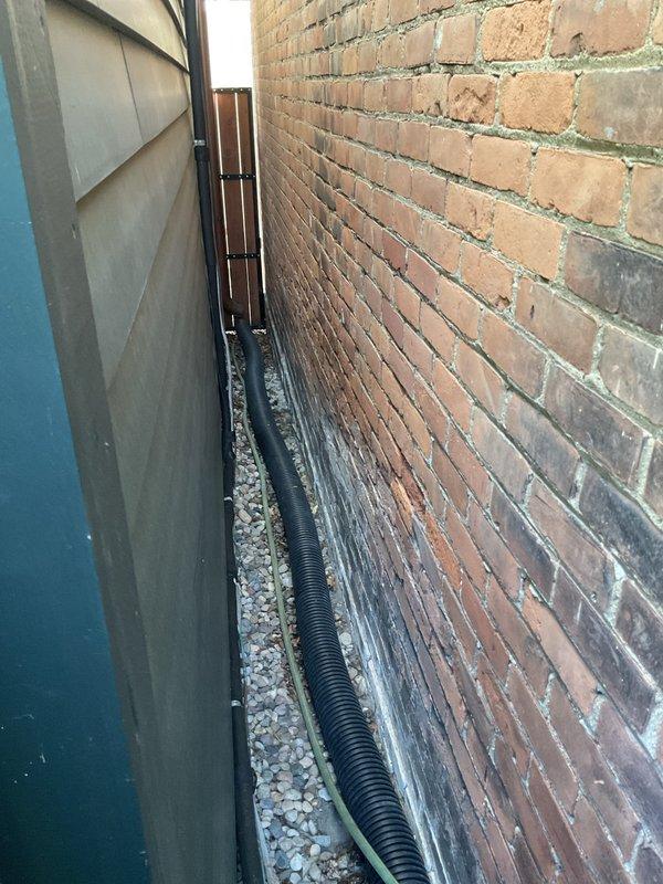 Completed installation of 1.5 ton air conditioning system with evaporator coil in rear yard location. Installed new condensing unit with proper refrigerant line connections, drainage system including corrugated discharge line positioned on gravel bed along foundation, and electrical reconnection. All mechanical and electrical permits obtained prior to installation, system tested and operational upon completion.