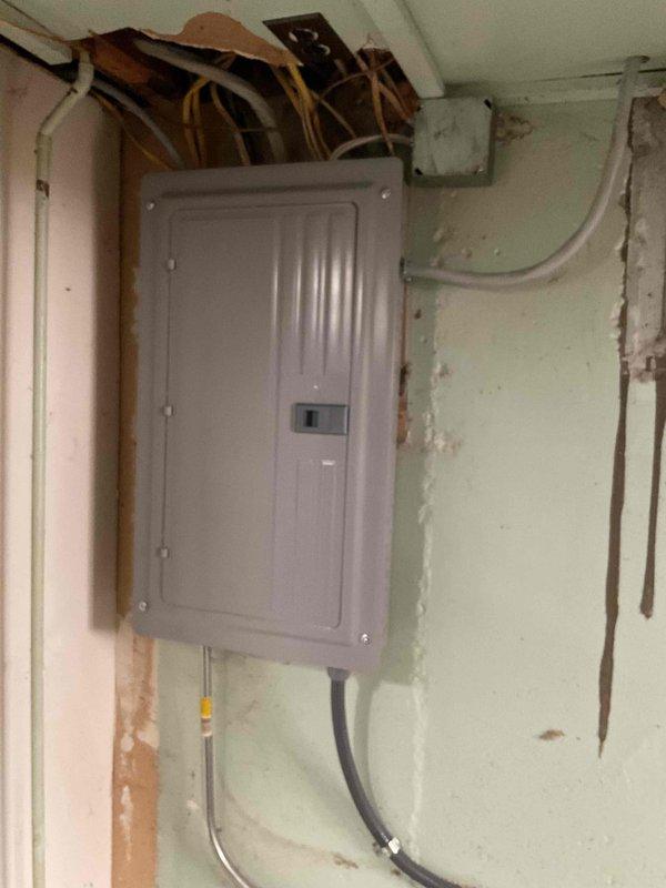 Installed new 100-amp electrical service panel in residential property, including mounting panel box on interior wall, routing and connecting main service conductors, installing proper conduit runs, and establishing grounding connections. Coordinated installation with concurrent HVAC system upgrade requiring panel integration for 70K BTU furnace, humidifier, and 2.5-ton air conditioning unit. All work completed in accordance with requested electrical permits and current NEC code requirements.