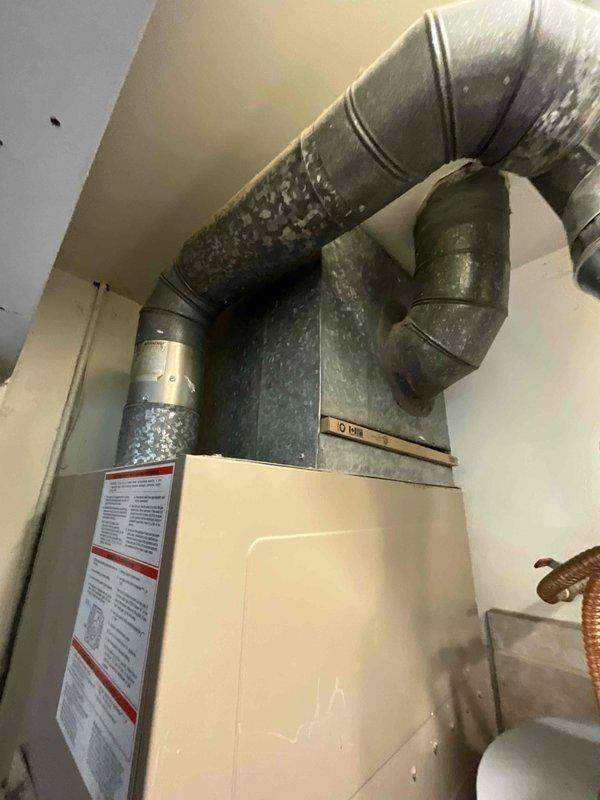 Completed full system HVAC estimate for medium-sized residential property (1200-2000 sq.ft.) requiring heating and cooling installation. Assessed existing closet-mounted furnace unit with extensive metallic ductwork system showing significant condensation accumulation on flexible aluminum ducts, indicating potential insulation deficiency or humidity control issues. Evaluated exterior electrical infrastructure including dual meter configuration and conduit system mounted on brick facade to ensure adequate power supply capacity for proposed natural gas or propane-fired heating and cooling equipment upgrade.