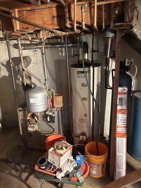 Conducted comprehensive site assessment for full system conversion from boiler heating to forced air HVAC system. Evaluated existing basement mechanical room layout, documented current water heater and plumbing infrastructure, and assessed structural considerations for ductwork installation throughout property. Property requires additional clearing and remediation work before final system design and installation can proceed, with follow-up coordination needed with installation engineering team to finalize equipment specifications and ductwork routing plan.