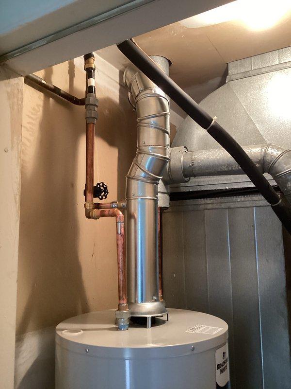 Installed a 40-gallon tanked water heater in residential utility area, including proper venting with metallic exhaust pipe system routed vertically through ceiling. Connected copper supply lines with shutoff valve, installed Icon System gas control unit with temperature regulation dial, and secured all gas line connections. Mechanical permit obtained for water heater installation and reconnection; all components tested and operational upon completion.