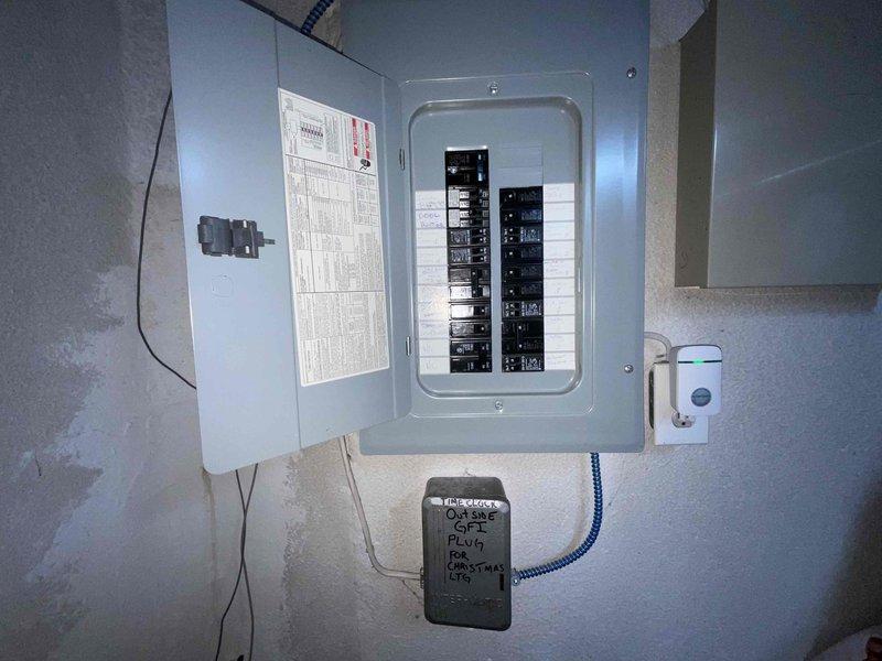Conducted on-site evaluation for Generac standby generator installation at a residential property built in 2001. Assessed existing electrical panel configuration and available space in utility area for generator transfer switch installation. Documented current electrical service setup, including main breaker panel with dual rows of circuit breakers and existing disconnect switch. Photographed installation site conditions to determine equipment placement, conduit routing requirements, and necessary modifications to accommodate automatic transfer switch and generator connection.