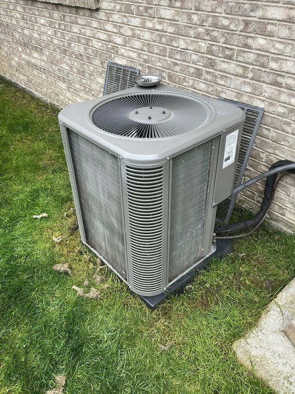 Completed annual maintenance on outdoor air conditioning condenser unit. Performed system inspection, changed air filter, and documented equipment condition with photos showing unit operating on concrete pad against exterior wall with visible wear consistent with outdoor installation.