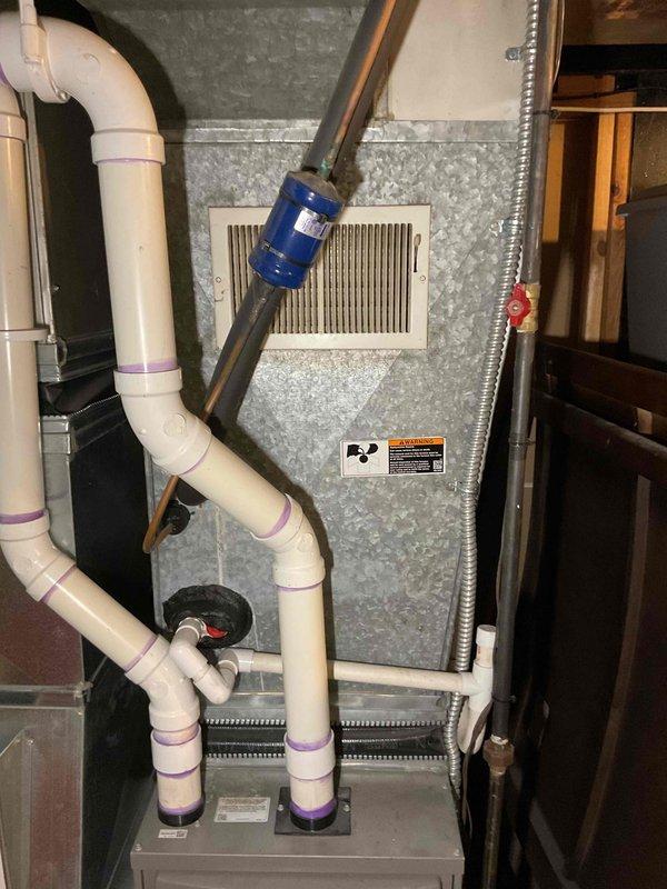 Provided estimate for air conditioning system replacement. Current outdoor unit is non-operational and of very old/unknown age. Site assessment completed with documentation of existing HVAC infrastructure including indoor air handler, furnace unit, condensate drainage system with PVC piping, refrigerant lines, and electrical components. Evaluated basement installation layout and existing ductwork configuration to determine appropriate replacement equipment specifications and installation requirements for new outdoor condensing unit.