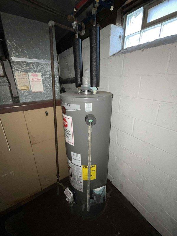 Conducted comprehensive evaluation of 30+ year old natural gas furnace and air conditioning system located in basement mechanical room. Assessed existing HVAC equipment condition, ductwork configuration, electrical service capacity, and gas line infrastructure. Documented current system specifications, measured available space for replacement equipment, and photographed existing installation including water heater proximity and utility connections. Reviewed ventilation requirements and discussed replacement options for complete furnace and A/C system upgrade to improve energy efficiency and reliability.