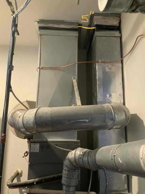 Conducted comprehensive evaluation of existing HVAC system for full replacement estimate, including air conditioning unit of unknown age and furnace approximately 23 years old. Documented current system configuration featuring vertical air handler assembly with flexible ductwork distribution, copper refrigerant lines, and existing furnace unit with metallic ductwork network. Assessed complete system for replacement recommendation, photographed existing installation showing plenum assembly, duct connections, electrical components, and overall mechanical room layout to provide accurate equipment sizing and installation planning for proposed new heating and cooling system.