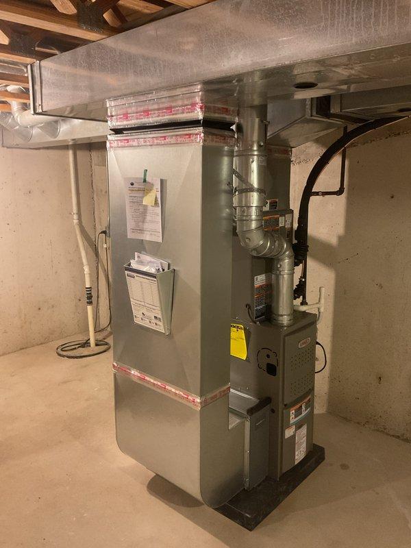Completed full HVAC system installation in residential basement including 70,000 BTU furnace and 2.5-ton air conditioning unit with front-discharge configuration. Installed furnace on platform with proper venting and ductwork connections, mounted evaporator coil assembly above furnace with metallic supply ductwork and elbow transitions to existing distribution system. Reconnected all electrical components, established refrigerant lines to outdoor condensing unit, and verified proper drainage connections. Mechanical and electrical permits obtained prior to installation. System tested and operational upon completion.