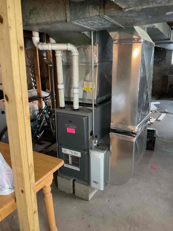 Conducted on-site assessment for air conditioning system installation in residential basement with existing furnace and ductwork infrastructure but no current A/C equipment in place. Evaluated basement HVAC configuration including furnace unit, metal plenum, ductwork routing to ceiling joists, and PVC condensate drainage system to determine specifications and requirements for new air conditioning equipment integration. Documented existing furnace location, available space for condenser placement, electrical service accessibility, and ductwork compatibility to prepare comprehensive estimate for complete A/C system installation.