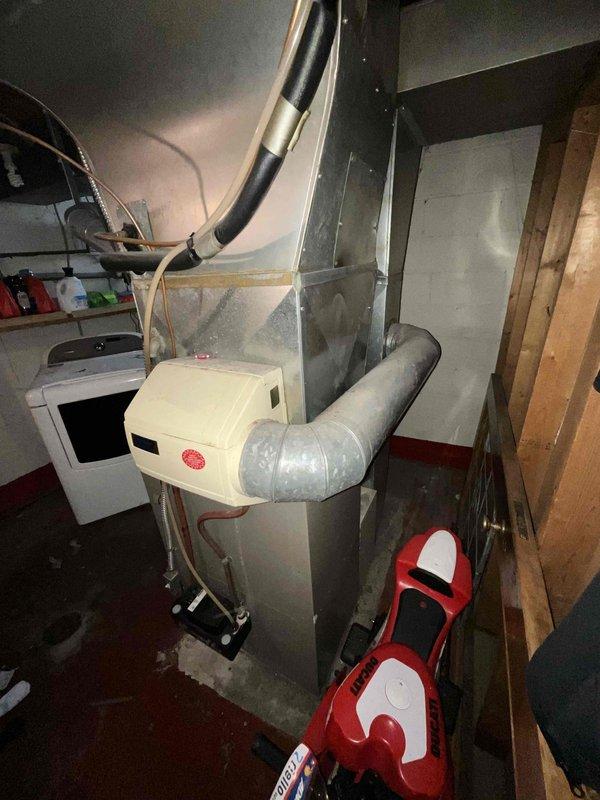 Conducted full system evaluation for 1500 square foot residential property with 16-year-old air conditioning unit requiring replacement. Inspected outdoor condensing unit showing significant debris accumulation around base and concrete pad, with visible wear on exterior casing and associated drainage components. Assessed indoor air handler and furnace assembly in basement mechanical room, including existing humidifier integration and ductwork configuration. Documented current equipment specifications, electrical connections, and refrigerant line routing to provide comprehensive replacement options for complete HVAC system upgrade within customer's requested two-week timeline.