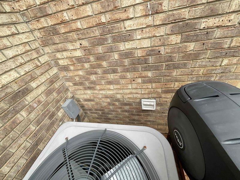 Completed new installation of tankless water heater at outdoor location adjacent to existing HVAC condenser unit. Unit mounted on exterior brick wall with proper venting, gas line connection, and electrical disconnect installed per manufacturer specifications and local code requirements.