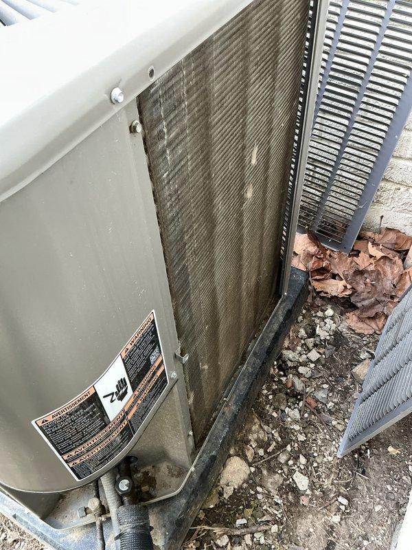 Completed scheduled maintenance on residential air conditioning system. Performed comprehensive inspection of outdoor condenser unit, noting weathered housing and accumulated debris around base. Cleaned condenser coils showing significant dirt accumulation and discoloration on heat exchanger fins. Replaced air filter per maintenance protocol. Verified unit operation and airflow through louvered panels and fan assembly. Equipment operational upon completion.