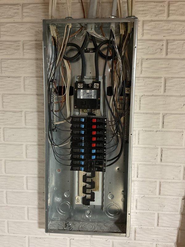 Completed comprehensive whole home electrical inspection of main service panel and distribution system. Evaluated service disconnect switch operation and verified proper labeling, documented dual-column circuit breaker configuration with color-coded toggle indicators for easy circuit identification. Inspected all branch circuit breakers for proper seating, secure connections, and appropriate amperage ratings. Assessed wire routing and organization within panel enclosure, confirmed proper conductor sizing and termination integrity at main lugs and individual breaker connections. Photographed panel configuration showing handwritten circuit directory identifying disposal and dishwasher circuits, noted mixed breaker indicator colors (blue and red) for visual circuit differentiation. Verified main disconnect functionality and panel grounding system compliance. All components found operational with no immediate safety concerns identified during inspection period.