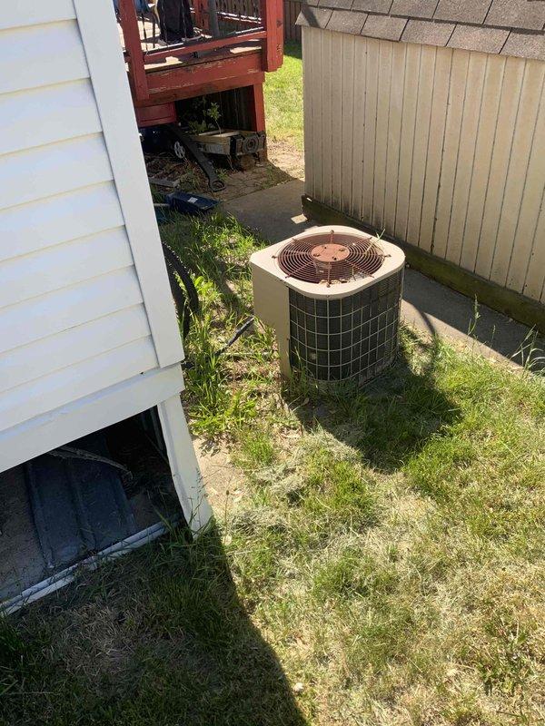 Provided estimate for replacement of non-operational outdoor air conditioning condenser unit aged 15+ years. Unit is located on exterior side yard area, positioned on ground level between main residence and secondary structure. Current equipment shows visible weathering and age-related deterioration, with unit no longer functioning and requiring full replacement to restore cooling capacity to the home.