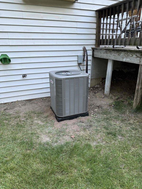 Successfully completed installation of a 2-ton air conditioning system with evaporator coil at rear of residence. Positioned outdoor condensing unit on pad against exterior siding with proper refrigerant line routing and electrical disconnect installation. Indoor evaporator coil installed in basement mechanical room with copper refrigerant lines, condensate drain piping, and electrical connections to existing furnace system. System properly charged, tested for proper operation, and all mechanical and air conditioning permits obtained prior to installation.