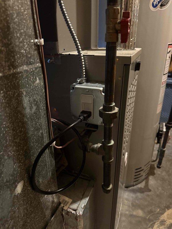 Successfully completed installation of a 2-ton air conditioning system with evaporator coil at rear of residence. Positioned outdoor condensing unit on pad against exterior siding with proper refrigerant line routing and electrical disconnect installation. Indoor evaporator coil installed in basement mechanical room with copper refrigerant lines, condensate drain piping, and electrical connections to existing furnace system. System properly charged, tested for proper operation, and all mechanical and air conditioning permits obtained prior to installation.