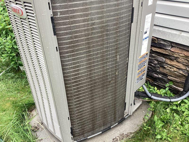 Responded to service call for Lennox air conditioning unit not cooling despite running. Upon inspection, found outdoor condenser unit with severely clogged condenser coils and filters restricting airflow. Unit was only 11 months old and still under parts and labor warranty. Cleaned condenser coils and replaced dirty filters to restore proper airflow through the system. Verified unit operation, confirmed adequate cooling performance restored, and system returned to normal functionality.