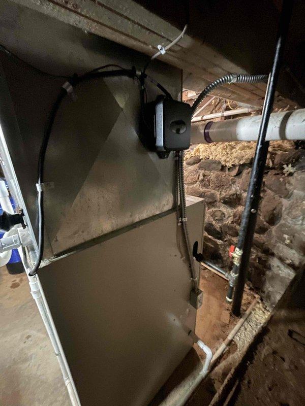 Completed installation of 2.5-ton Lennox air conditioning condenser unit and evaporator coil system at residential property. Outdoor condenser positioned on rubber isolation pad in rear yard location with proper clearance from fence and structure, electrical disconnect installed on exterior wall, and refrigerant lines connected. Indoor evaporator coil installed in basement area with existing furnace system, all ductwork connections completed, and system tested for proper operation and refrigerant charge.