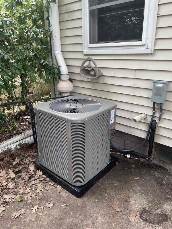 Completed installation of 2.5-ton air conditioning system with matching evaporator coil. Outdoor condenser unit positioned on rubber pad on right side of residence with proper electrical disconnect and conduit connections. Indoor coil integrated with existing furnace system, humidifier reconnected to complete HVAC setup.