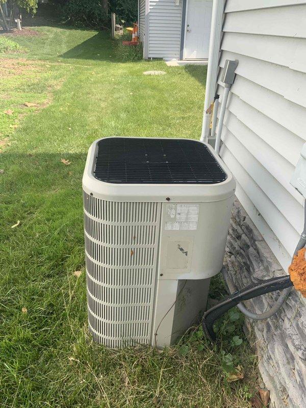 Provided estimate for complete air conditioning system replacement at residential property. Existing 10+ year old outdoor condenser unit located on exterior concrete pad and indoor air handler in utility closet are non-operational and require full system replacement. Documented current equipment configuration including outdoor condensing unit with beige cabinet positioned against house siding and indoor air handling equipment with Trion Air Bear filtration system housed in mechanical closet with associated ductwork connections.