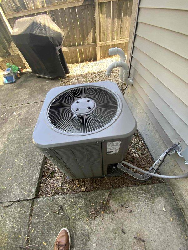 Conducted full system evaluation on 7-year-old Lennox HVAC system experiencing inadequate cooling performance with temperature delta consistently measuring only 10-12 degrees, previously diagnosed with failed compressor. Inspected outdoor condenser unit with gray rounded housing positioned on concrete patio, noting refrigerant line connections and electrical conduit routing along exterior wall. Evaluated indoor furnace unit and air handler located in basement utility area, examining ductwork connections and system configuration. Documented equipment condition through comprehensive photography of both outdoor and indoor components. Provided complete system replacement estimate as repair of compressor deemed not cost-effective given age of equipment and performance issues.