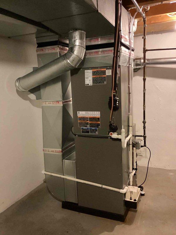 Completed full HVAC system installation including 90,000 BTU furnace, 3.5-ton air conditioning unit with matching evaporator coil, and humidifier in basement location. Installation included rear-discharge outdoor unit placement, refrigerant line set connection, condensate drain piping with PVC routing, electrical connections, and ductwork transitions. All equipment installed per manufacturer specifications, system tested and operational, mechanical permit obtained prior to installation.