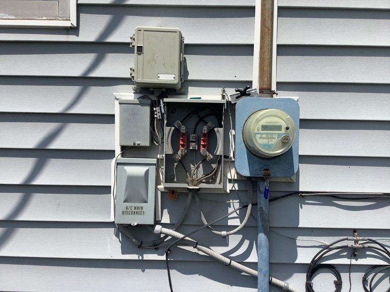 Responded to callback for AC unit not cooling properly. Upon arrival, inspected exterior electrical service panel and AC main disconnect per customer request following their contact with utility company regarding power supply concerns. Previous technician had not accessed furnace area or checked fusing as requested. Verified proper voltage at meter and service panel, inspected circuit breakers and AC disconnect switch, documented electrical connections and service entrance components. Found electrical supply adequate with no immediate safety concerns at disconnect panel. Photographed electrical service equipment showing weathered connections and age-related corrosion on bus bars and terminals typical of older installations. Confirmed 15-year-old outdoor AC unit receiving proper power supply at disconnect.