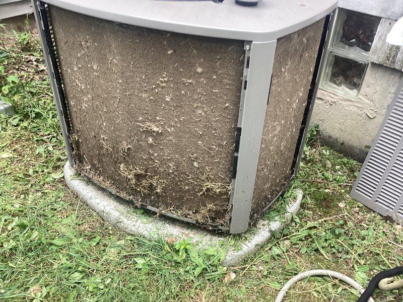 # No Cooling - Restricted Airflow Due to Debris Accumulation

Responded to no cooling complaint on 2-year-old residential air conditioning system. Upon arrival, performed visual inspection of outdoor condensing unit and identified severe airflow restriction caused by extensive debris accumulation on condenser coil screens. Filter screens were completely obstructed with thick layer of grass clippings, leaves, dirt, and organic matter, preventing proper air circulation through the unit.

Removed top panel and fan assembly to access condenser coils. Carefully cleaned all exterior screens and condenser coil fins, removing matted debris buildup. Utilized appropriate cleaning tools and techniques to restore full airflow capacity without damaging delicate aluminum fins. Verified condenser fan motor operation and inspected electrical connections.

Reassembled unit, secured all panels and fasteners. System tested and confirmed proper operation with adequate airflow and cooling performance resto