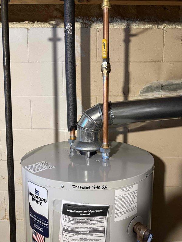 Installed a new 50-gallon Bradford White residential tank-type water heater in basement utility area. Removed existing unit and connected new water heater with copper supply piping, brass shut-off valves, and proper venting through aluminum flue pipe. Completed all hot and cold water connections, installed temperature and pressure relief valve with discharge piping, and ensured proper clearances per manufacturer specifications. Tested unit operation, verified all connections for leaks, and confirmed proper venting and combustion air supply. Installation performed in compliance with local plumbing codes and permit requirements.