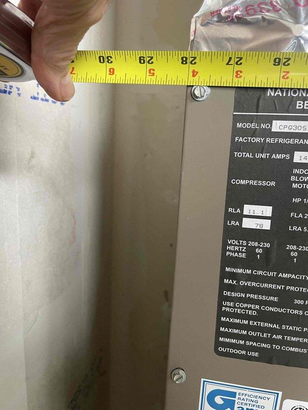 Provided estimate for replacement of air conditioning and furnace system in first-floor condo unit. Current equipment dating from 2008 is still operational but approaching end of service life. Existing HVAC system is located in mechanical room on enclosed porch area. Measured existing unit dimensions and documented current equipment specifications, including CPG305 model operating at 208-230V with 11.1 RLA and 78 LRA ratings. Assessed installation space constraints and insulation conditions to determine proper sizing and placement requirements for replacement equipment.