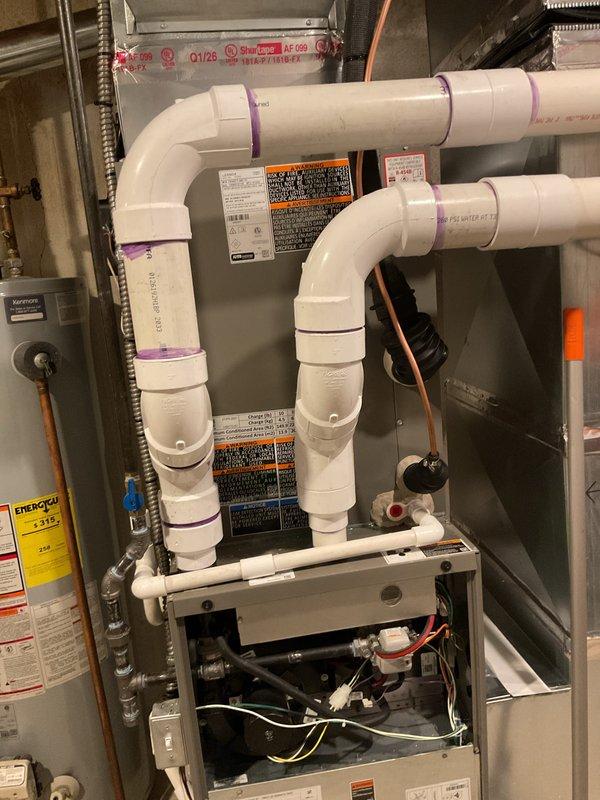 Completed installation of 3-ton air conditioning system with matching evaporator coil in residential basement utility area. Installed new air handler unit with proper refrigerant line connections, configured right-side discharge orientation, and integrated PVC condensate drainage system with appropriate trap configuration. Performed electrical and mechanical reconnections to existing furnace infrastructure, verified all connections, and ensured system meets mechanical and electrical permit specifications for final inspection.