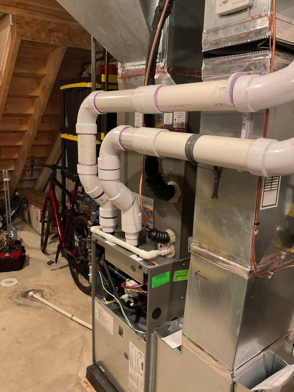 Completed installation of 3-ton air conditioning system with matching evaporator coil in residential basement utility area. Installed new air handler unit with proper refrigerant line connections, configured right-side discharge orientation, and integrated PVC condensate drainage system with appropriate trap configuration. Performed electrical and mechanical reconnections to existing furnace infrastructure, verified all connections, and ensured system meets mechanical and electrical permit specifications for final inspection.
