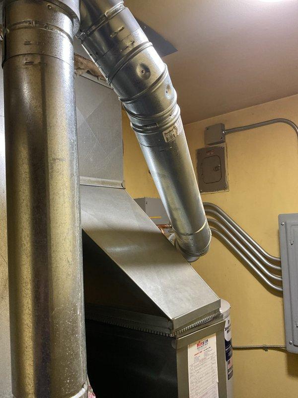 Completed call-back service to address code violations identified during initial 40-gallon natural draft water heater installation. Installed combustion air openings to furnace/water heater room per code requirements, providing one square inch per 1000 BTU input of appliances with high opening at ceiling level and low opening at floor level. Secured water heater draft diverter with four screws per manufacturer specifications to ensure proper venting operation and code compliance.