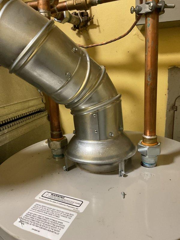 Completed call-back service to address code violations identified during initial 40-gallon natural draft water heater installation. Installed combustion air openings to furnace/water heater room per code requirements, providing one square inch per 1000 BTU input of appliances with high opening at ceiling level and low opening at floor level. Secured water heater draft diverter with four screws per manufacturer specifications to ensure proper venting operation and code compliance.