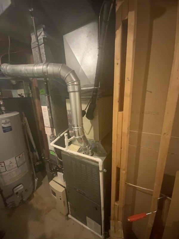 Provided comprehensive estimate for replacement of 30+ year old non-operational natural gas furnace located in basement. Assessed existing HVAC system including ductwork configuration, exhaust venting, and spatial requirements for new equipment installation. Documented current system layout with metal ductwork runs, existing furnace unit with exhaust vent pipe, and proximity to water heater to determine optimal replacement specifications and installation approach.