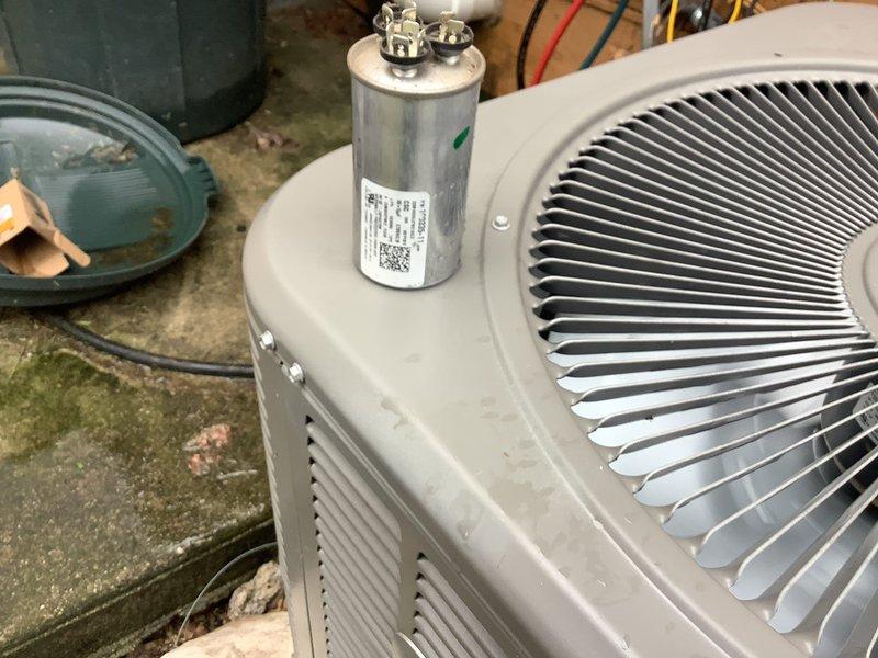 Responded to no cooling complaint on 5-year-old central air conditioning system blowing warm air. Inspected outdoor condenser unit and found capacitor showing signs of failure. Evaluated Honeywell thermostat operation and confirmed proper communication between thermostat and system. Replaced dual-run capacitor to restore proper compressor and fan motor operation. System tested and verified cooling functionality restored to normal operating parameters.