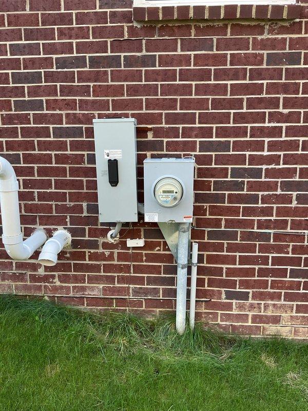 Installed exterior weatherproof electrical outlet on brick wall near existing electrical meter and disconnect panel to accommodate portable generator connection. Ran conduit and wiring from main electrical panel, ensuring proper grounding and code-compliant installation for outdoor generator use.