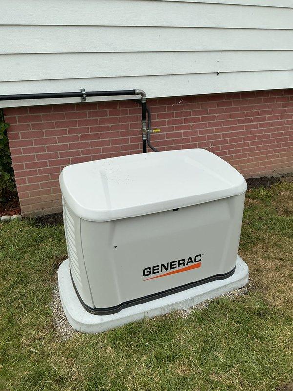 Successfully completed installation of 14kW Generac standby generator system at residential property. Generator unit mounted on concrete pad adjacent to building foundation with proper clearances maintained, electrical connections established through conduit run to interior transfer switch panel mounted on basement wall. All permit requirements fulfilled, system tested and operational.