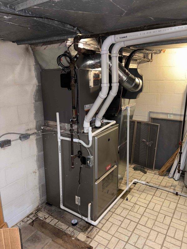 Completed installation of 3-ton air conditioning system with evaporator coil in basement utility area. Connected new Bryant furnace to existing ductwork infrastructure, installed condensate drainage system with white PVC piping, and integrated metallic flex ductwork to air handler. Reconnected electrical components, verified proper airflow through supply and return ducts, and ensured all connections were secure and code-compliant per mechanical permit requirements.