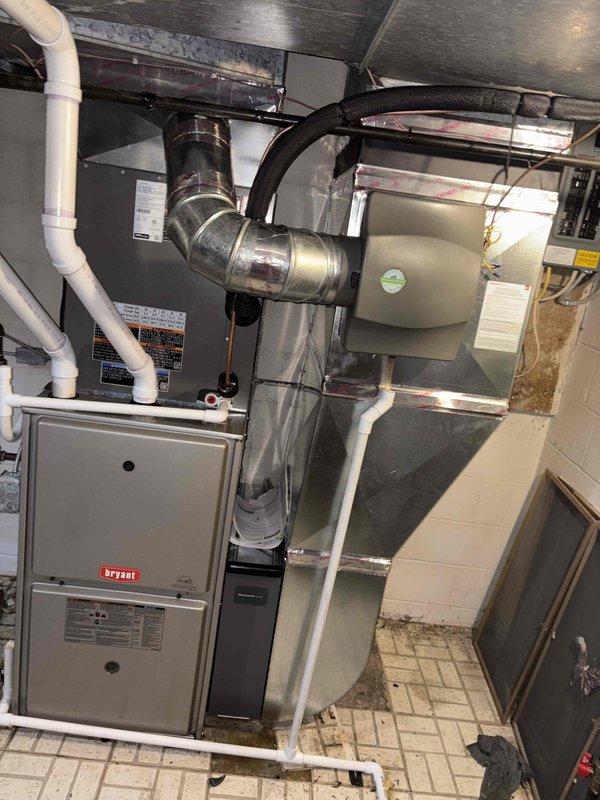 Completed installation of 3-ton air conditioning system with evaporator coil in basement utility area. Connected new Bryant furnace to existing ductwork infrastructure, installed condensate drainage system with white PVC piping, and integrated metallic flex ductwork to air handler. Reconnected electrical components, verified proper airflow through supply and return ducts, and ensured all connections were secure and code-compliant per mechanical permit requirements.
