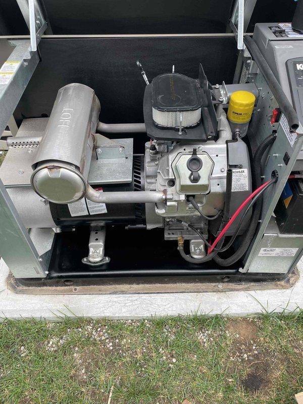 Completed electrical maintenance on a Kohler 20kW standby generator unit. Performed routine inspection of engine components, verified proper mounting of exhaust system and muffler assembly, and documented equipment condition through photographic records per maintenance protocol.