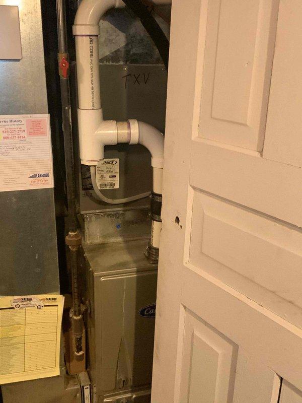Conducted full system estimate for replacement of existing 16-20 year old furnace installation in basement utility room. Evaluated current HVAC equipment including gray metal furnace unit with associated ductwork, PVC drainage system with shutoff valve, and beige air handler with copper refrigerant lines. Customer requires immediate replacement due to age of existing equipment; air conditioning system was previously replaced in 2023.