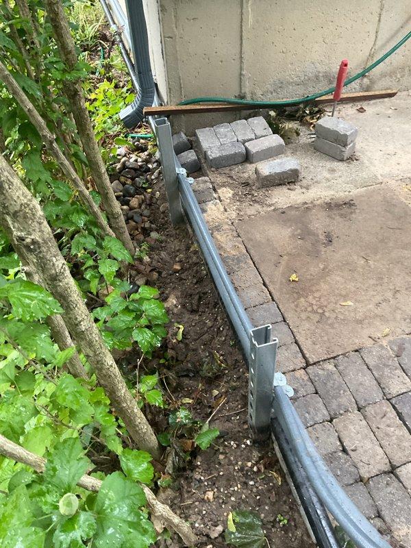 Responded to callback for ATS communication warning, not in auto warning, and date/time warning on recently installed HVAC system. Retrieved gauge and go equipment from site as scheduled. Verified outdoor unit installation and condensate drainage system properly secured with appropriate brackets and straps. Documented equipment placement and utility connections in outdoor service area adjacent to building foundation for service records.