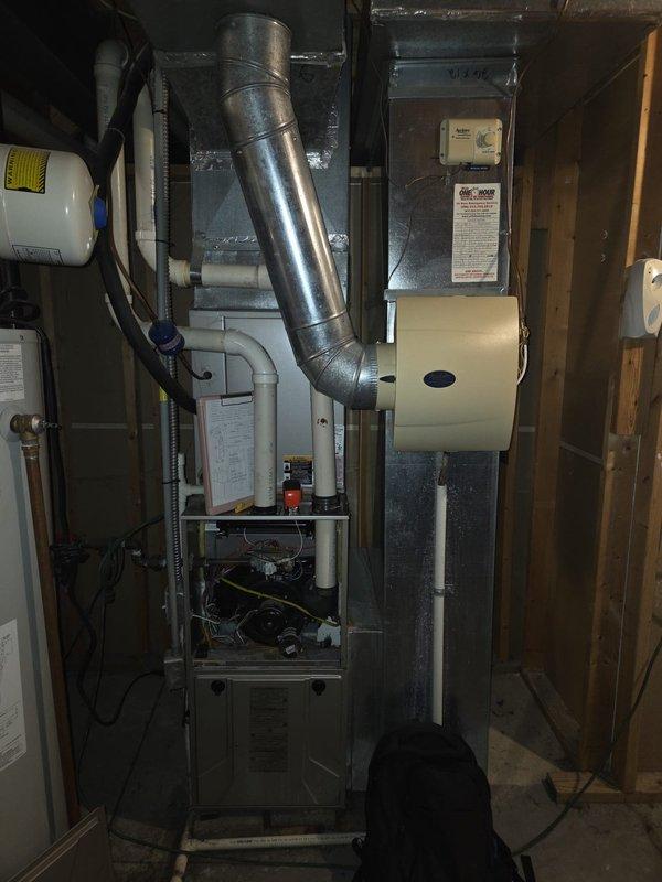 Performed comprehensive assessment of aging gas HVAC system (15+ years) including furnace unit with connected circular metal ductwork, PVC venting, and associated air handler. Evaluation included inspection of crawlspace installation conditions, examining both the main equipment and auxiliary components including ductwork integrity, condensate drainage system, and thermostat functionality. Documented current system configuration to prepare replacement recommendations for complete furnace and AC unit upgrade.